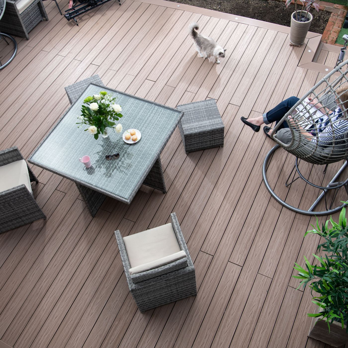 Woman sitting in a hanging chair on her Alchemy Habitat decking