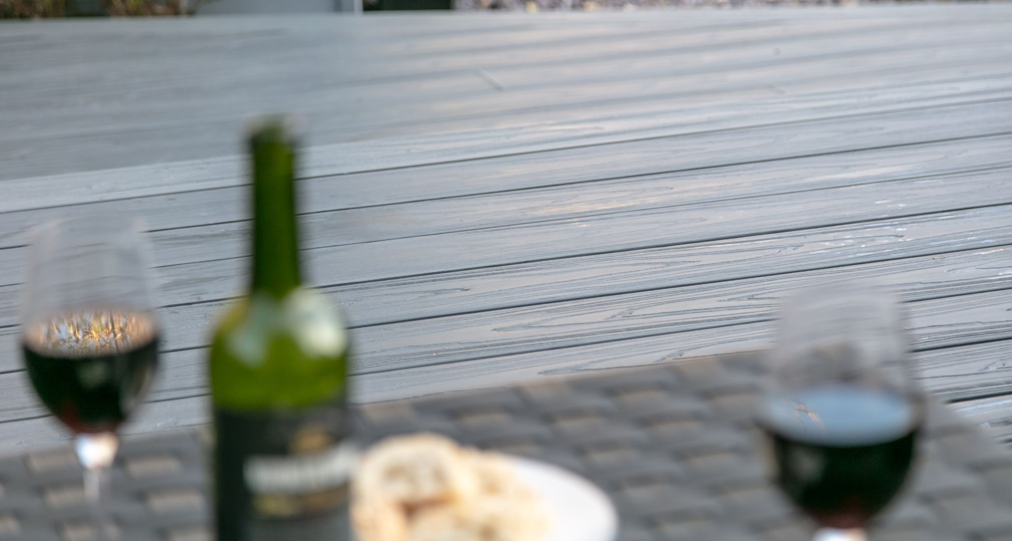 Alchemy decking as seen from a sofa with glasses of wine on a table